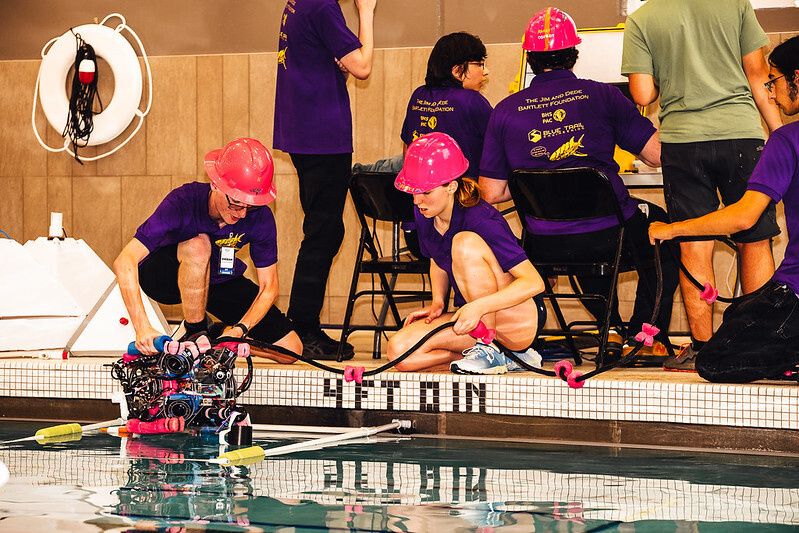 Students putting ROV in pool at MATE ROV Competition
