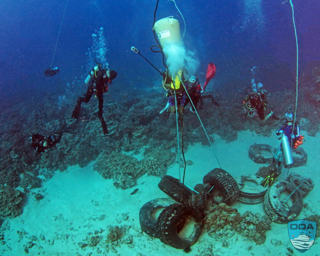 Divers cleaning up tires in Kailua Bay